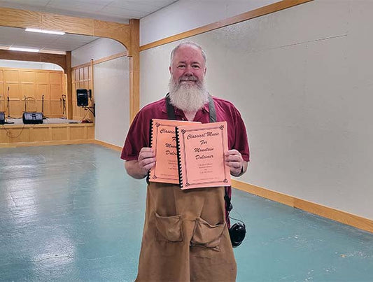 richard ash holding two of shelley stevens baker's dozen books that he just finished binding