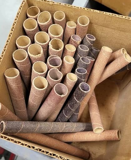 a cardboard box holding various sizes of sandpaper cylinders